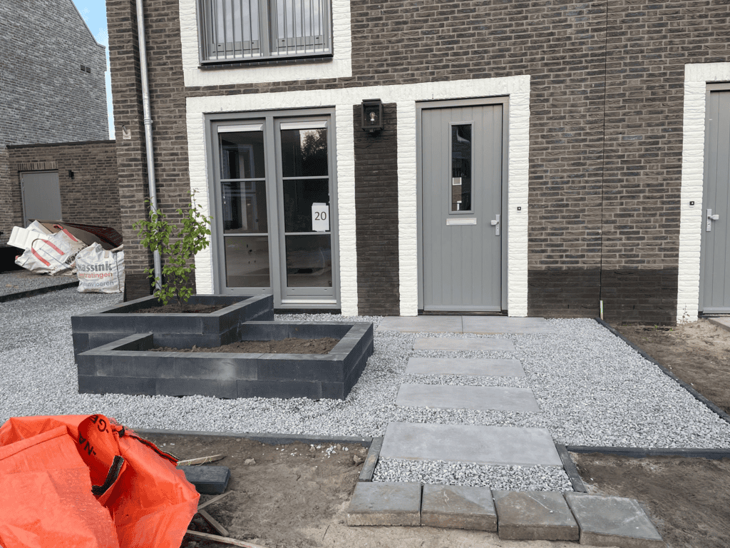 Klein tuinontwerp met grind en sierbestrating voor modern huis, geschikt voor aanleg en tuinarchitectuur.