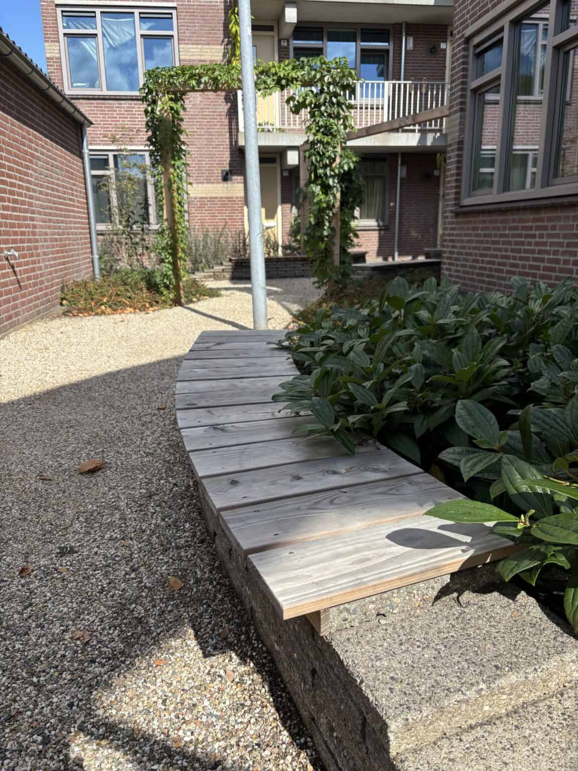 Veranda en tuinbank in moderne tuin met planten en stenen terras.