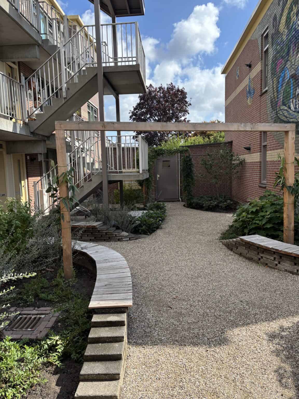 Kunstgras tuin met zitbank en houten pergola, modern tuinontwerp met kleurrijke gevels.